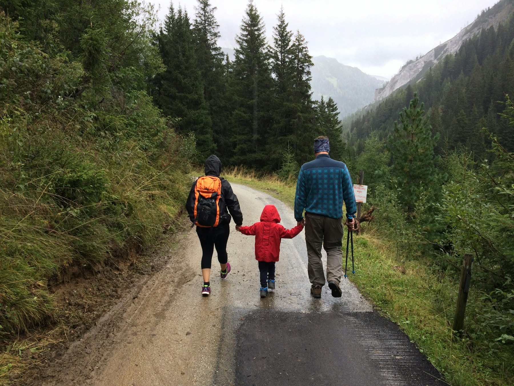 A family walking together outdoors along a dirt path