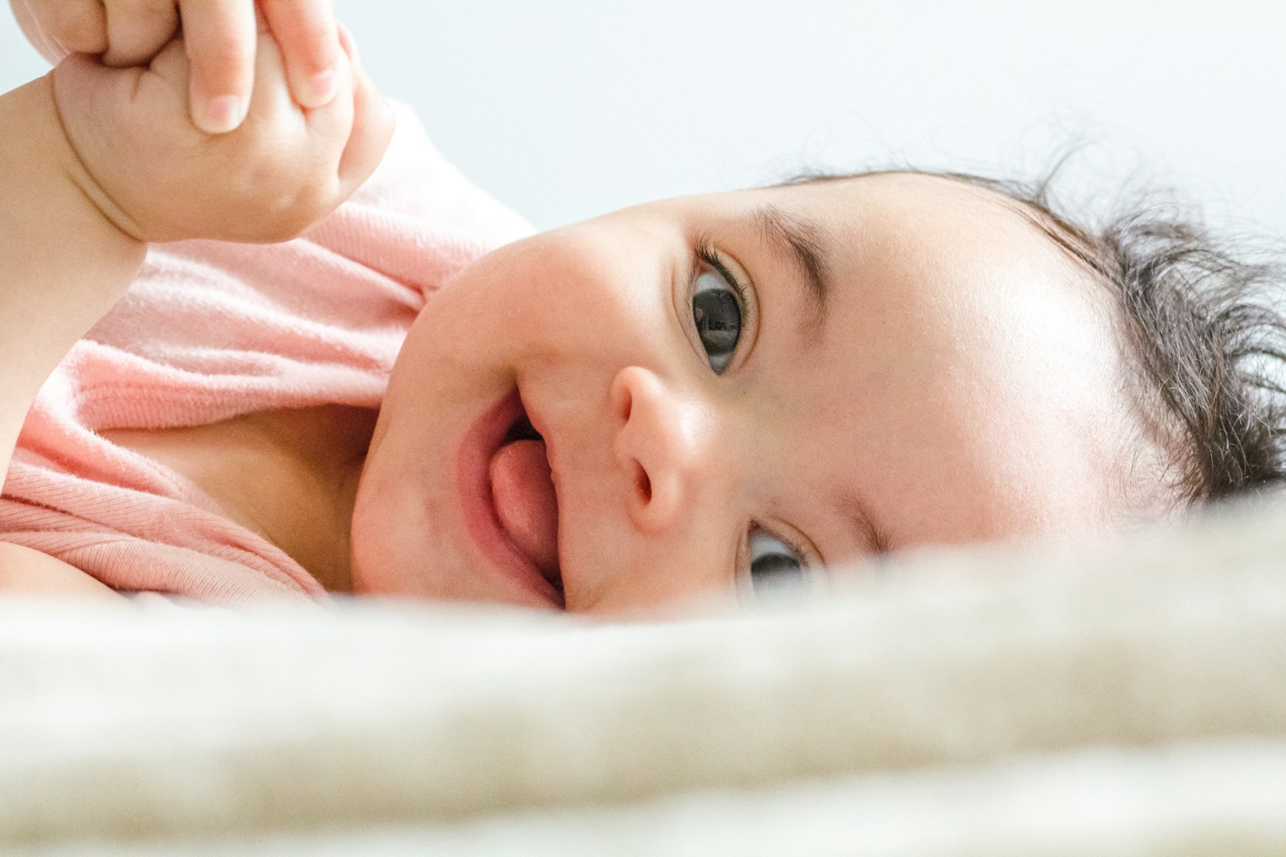 A smiling infant looking up, indoors