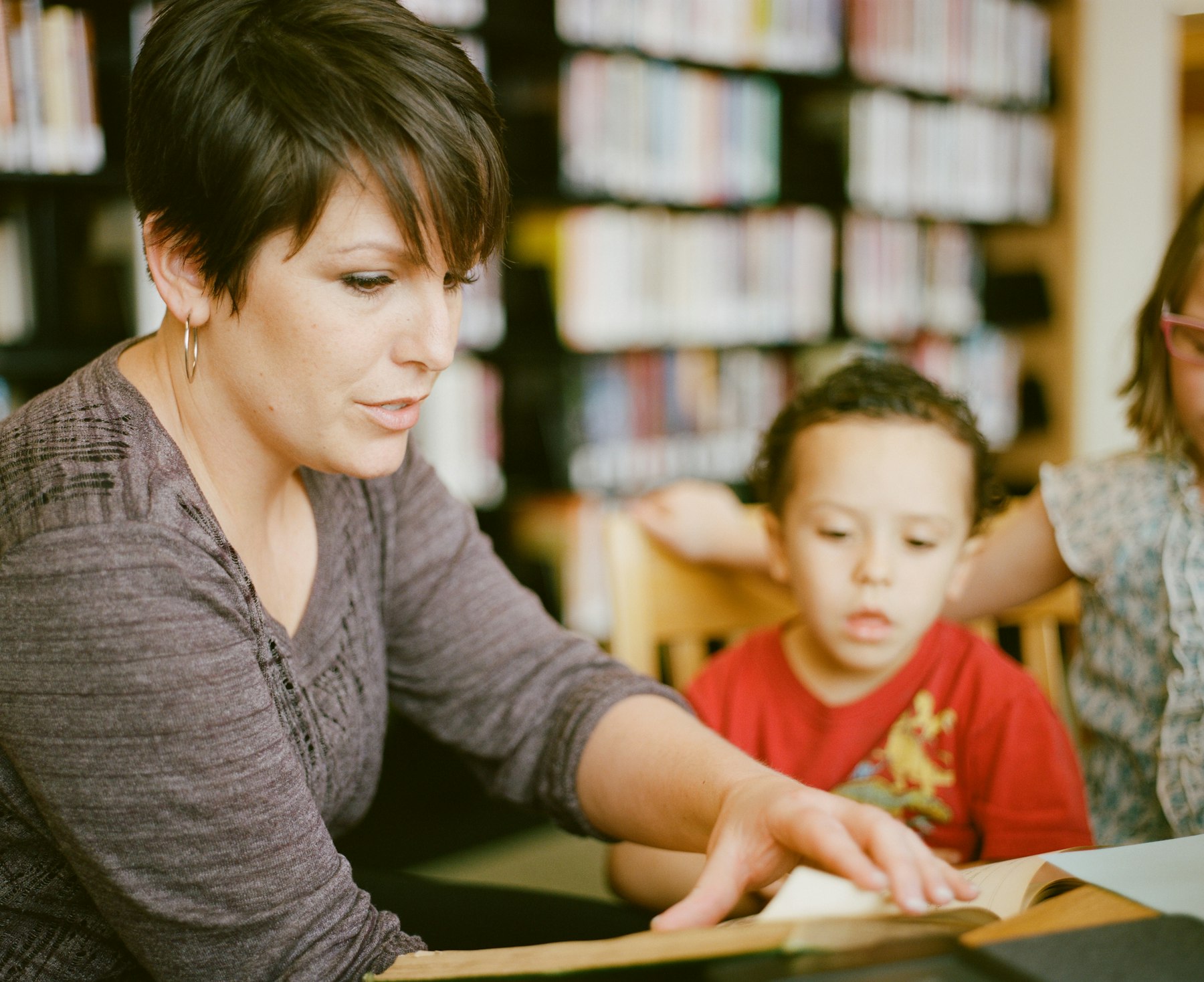 A teacher warmly reading with young children